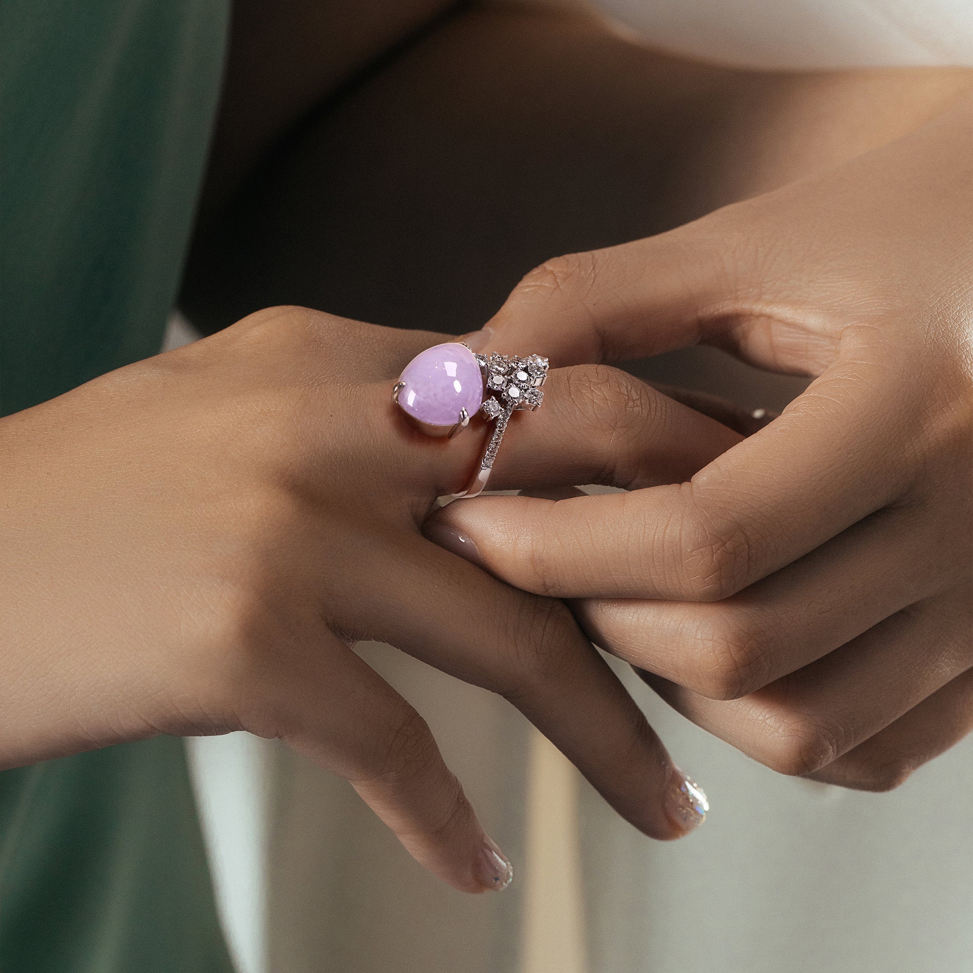 The model wore a uniquely shaped purple jade and a uniquely designed ring with multiple diamonds.