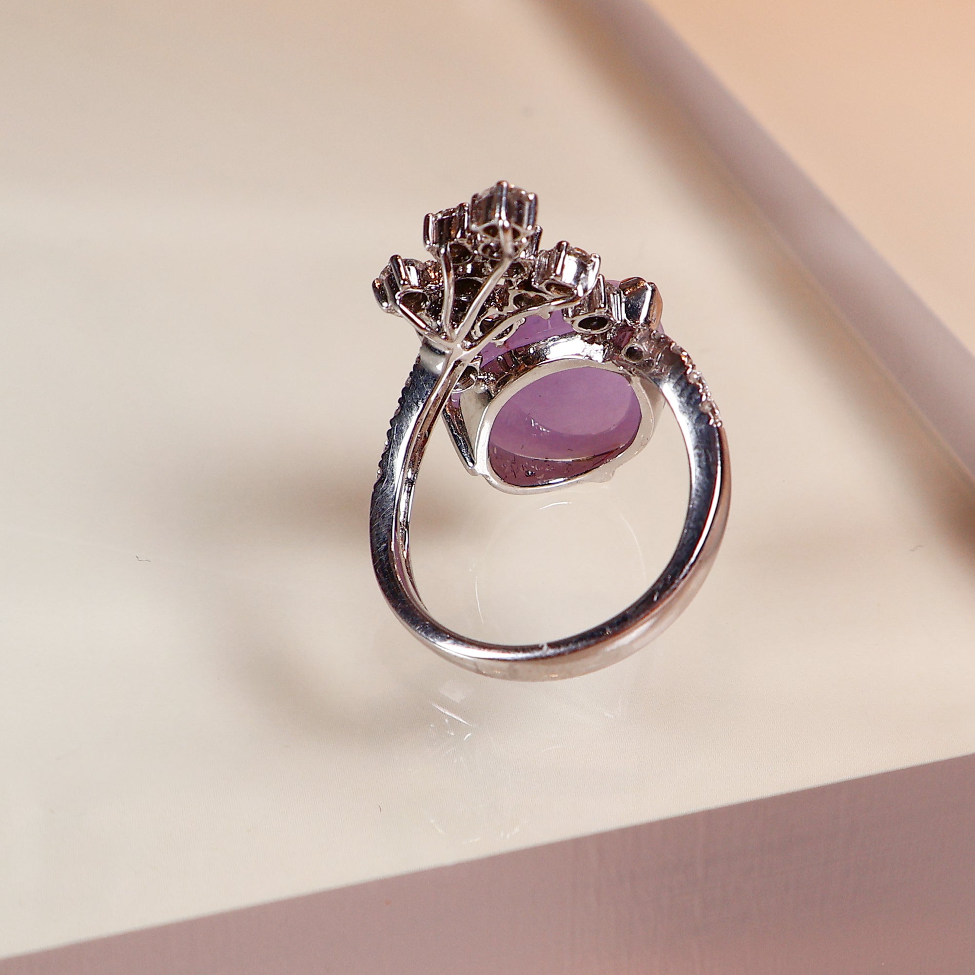 A uniquely shaped purple jade and a uniquely designed ring with multiple diamonds